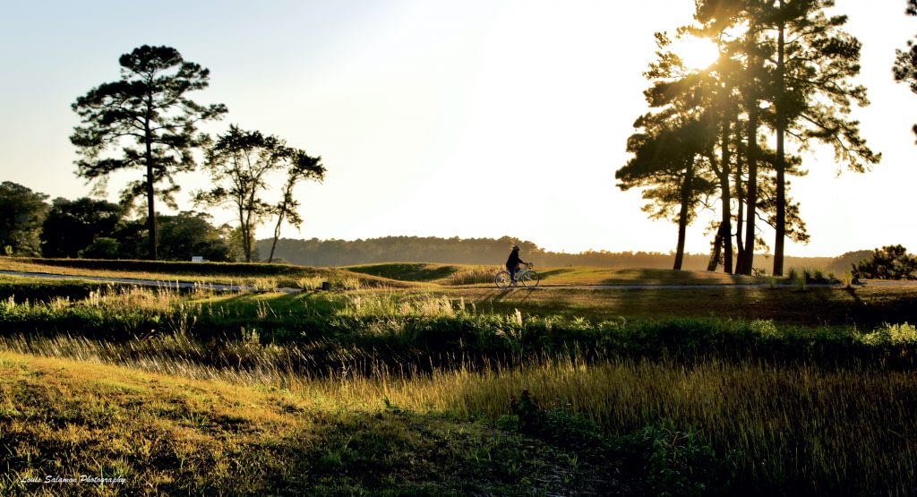 Female bike rider at sunset by river