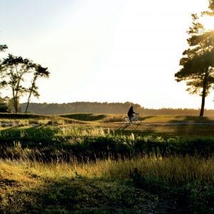 Female bike rider at sunset near river